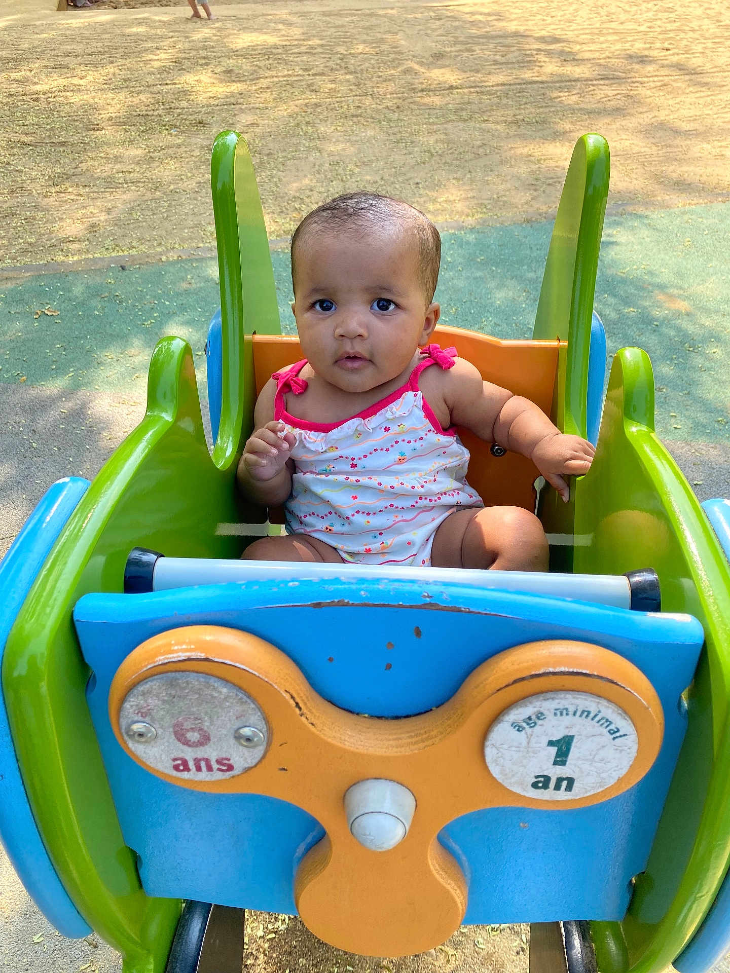 Thaïssy participe au concours pour gagner de l'argent avec cette photo : baby, child, playground, ride, colorful, outdoor, summer, cute, infant, seat, toy, park, green, blue, orange, expression, face, person, sitting, sunlight