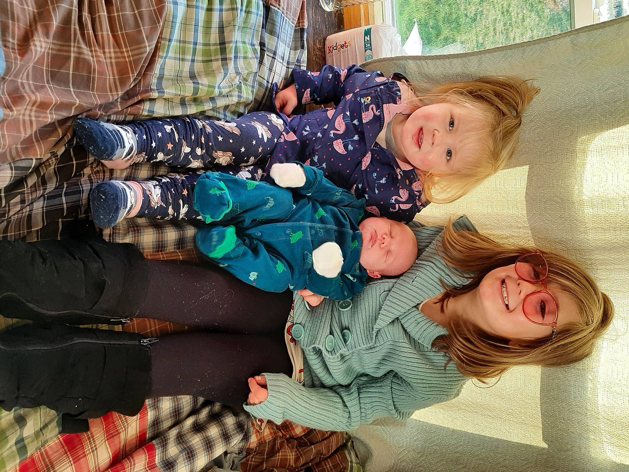 Elias is registered to the contest to win money with this photo: comfort, event, fun, happy, joy, lap, leisure, pattern, person, plaid, sitting, smile, tartan, textile, toddler, tree, winter