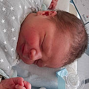 Mario Cros participe au concours pour gagner de l'argent avec cette photo : baby, blanket, closeup, cozy, cute, face, hand, hospital_crib, infant, name_tag, newborn, nursery, pacifier, plush_toy, resting, skin, sleeping, soft_toy, star_pattern, wrapped