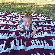 Karson joined the competition — help win amazing prizes! baby, child, blanket, outdoor, grass, sunlight, smiling, happy, person, car, vehicle, nature, greenery, clothing, head, face, playing, summer, relaxing, yard