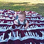 baby, child, blanket, outdoor, grass, sunlight, smiling, happy, person, car, vehicle, nature, greenery, clothing, head, face, playing, summer, relaxing, yard