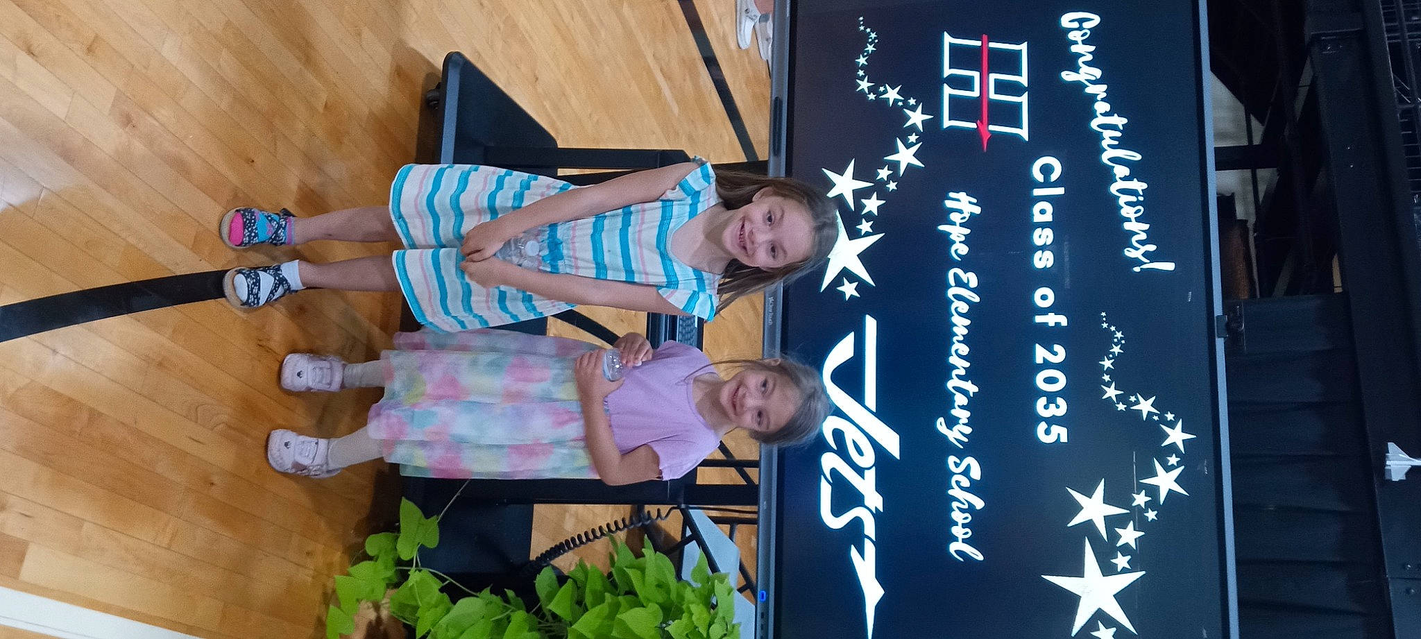 Emily is registered to the contest to win money with this photo: advertising, child, electric_blue, event, font, fun, happy, joy, leisure, logo, person, plant, sandal, shorts, signage, smile, t_shirt