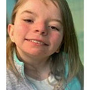 Anna is registered to the contest to win money with this photo: child, girl, smile, portrait, face, young_child, blonde_hair, long_hair, jacket, zipper, indoors, closeup, rosy_cheeks, teeth, happy, head_tilt, casual_clothing, background_blur, watermark, person