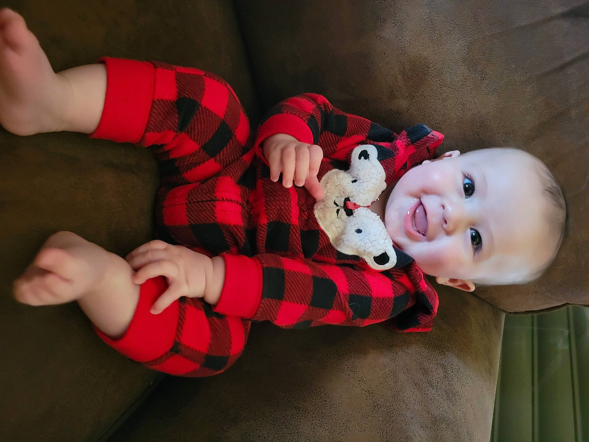 George is registered to the contest to win money with this photo: arm, baby, baby_toddler_clothing, eye, face, hand, human_body, leg, mammal, mouth, person, plaid, plant, product, skin, smile, tartan, textile, thigh, toy