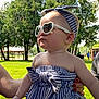 Vivian joined the competition — help win amazing prizes! baby, child, sunglasses, headband, striped_clothing, outdoor, park, grass, trees, sunlight, person, hand, red_nail_polish, summer, cute, fashion, infant, portrait, casual, holding