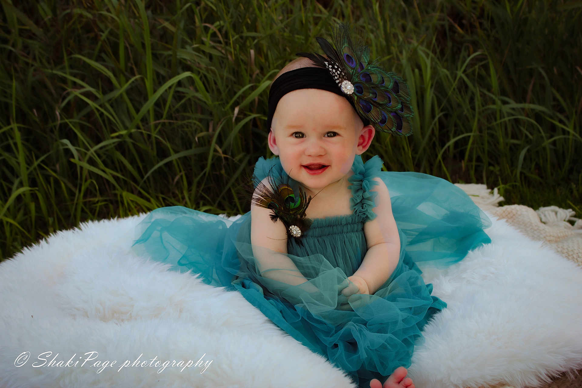 Vivian joined the competition — help win amazing prizes! baby, child, smiling, tutu, dress, headband, peacock_feathers, grass, outdoor, blanket, fluffy, happy, cute, portrait, sitting, nature, young, person, fashion, photography