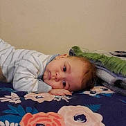 Khaled joined the competition — help win amazing prizes! toddler, child, bed, blanket, floral_pattern, indoor, resting, face, calm, portrait, person, sleepwear, young_child, cozy, expression, hand, head, lying_down, home, soft_lighting