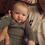 Kinsleigh is registered to the contest to win money with this photo: baby, child, person, adult, sweater, knitwear, hand, face, indoor, furniture, dresser, bottle, can, clothing, portrait, expression, holding, adult_hand, cozy, casual