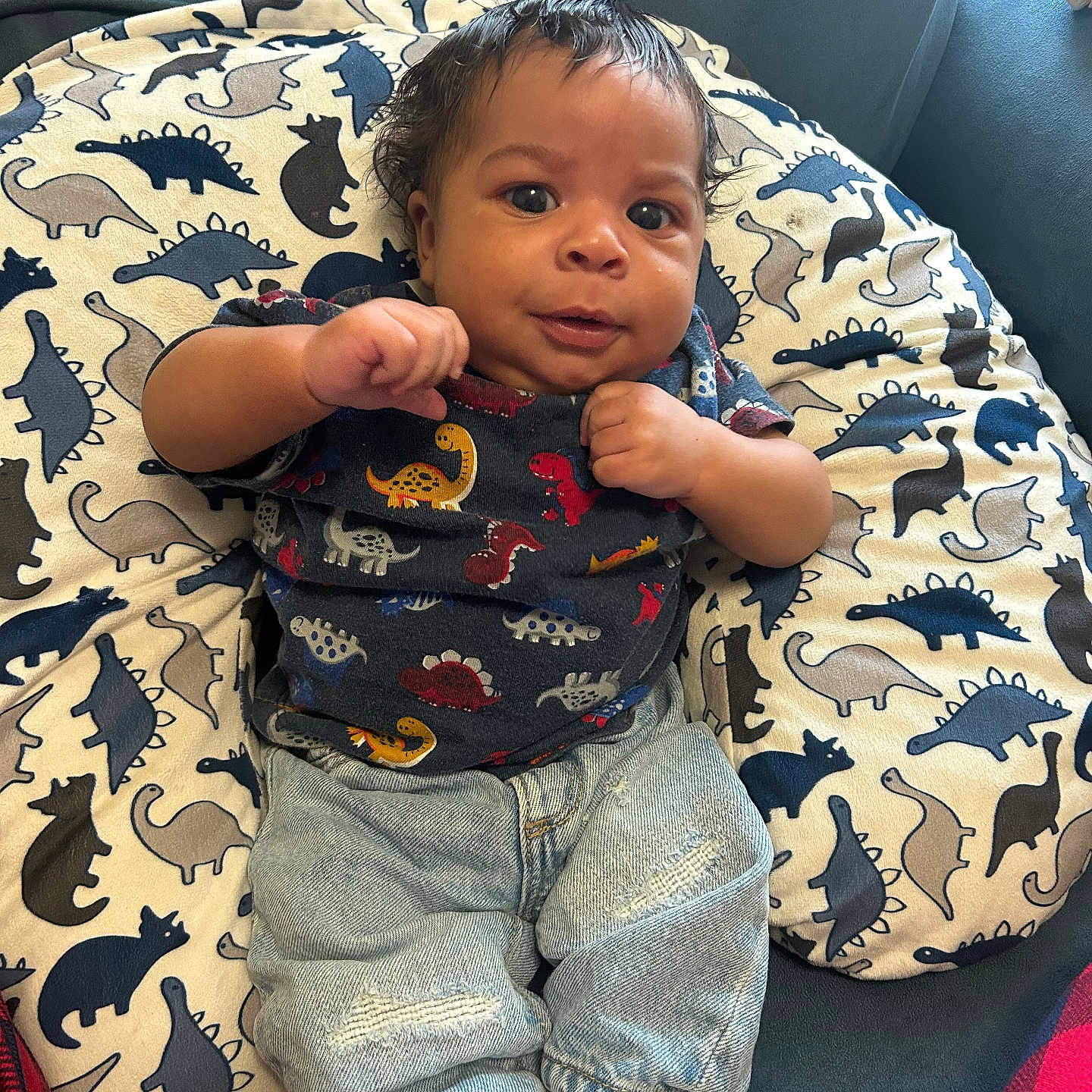 Daemyris joined the competition — help win amazing prizes! baby, casual_wear, child, clothing, couch, curly_hair, cute, dinosaur_print, furniture, indoor, infant, jeans, pattern, person, pillow, portrait, seated, smiling, socks, textile