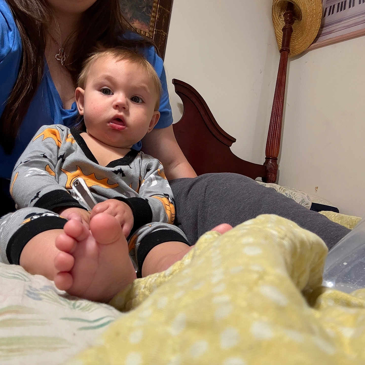 Harvey Dallas Cannon joined the competition — help win amazing prizes! adult, baby, bed, blanket, blue_shirt, bottle, child, clothing, face, foot, furniture, hair, hand, headboard, indoor, pajamas, person, sitting, toy, yellow_blanket