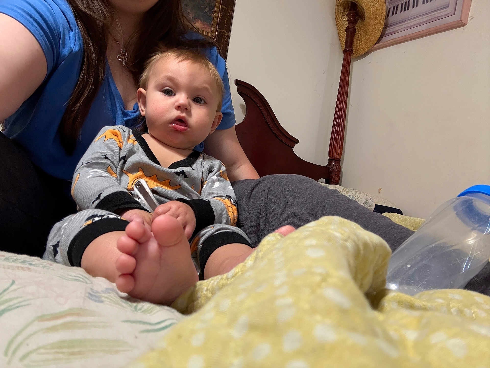 Harvey Dallas Cannon joined the competition — help win amazing prizes! baby, child, adult, bed, blanket, bottle, foot, pajamas, person, furniture, headboard, hair, face, hand, sitting, indoor, clothing, toy, yellow_blanket, blue_shirt