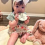 baby, child, infant, headband, bow, plush_toy, pink, floral_dress, sitting, chewing, wooden_plaque, eight_months, soft_mat, cute, indoors, floor, toy, person, young_child, playtime