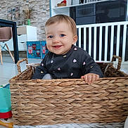 Iris participe au concours pour gagner de l'argent avec cette photo : baby, child, basket, smiling, indoor, blue_eyes, woven, furniture, toy, floor, cute, happy, person, clothing, home, decor, hand, sitting, playful, toddler