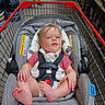 baby, car_seat, shopping_cart, child, store, aisle, sitting, straps, footwear, clothing, person, retail, shelves, product, indoor, shopping, cute, infant, grocery, supermarket