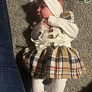 Bayleigh joined the competition — help win amazing prizes! baby, infant, plaid_skirt, white_knitwear, headband, bow, carpet, pacifier, white_shoes, baby_clothes, legs, denim, indoor, cute, lying_down, child, small, footwear, comfortable, portrait