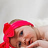 Bayleigh joined the competition — help win amazing prizes! baby, infant, headband, pink_bow, blue_eyes, face, skin, hand, fluffy, soft_texture, closeup, portrait, cute, resting, child, newborn, expression, innocent, indoors, white_background
