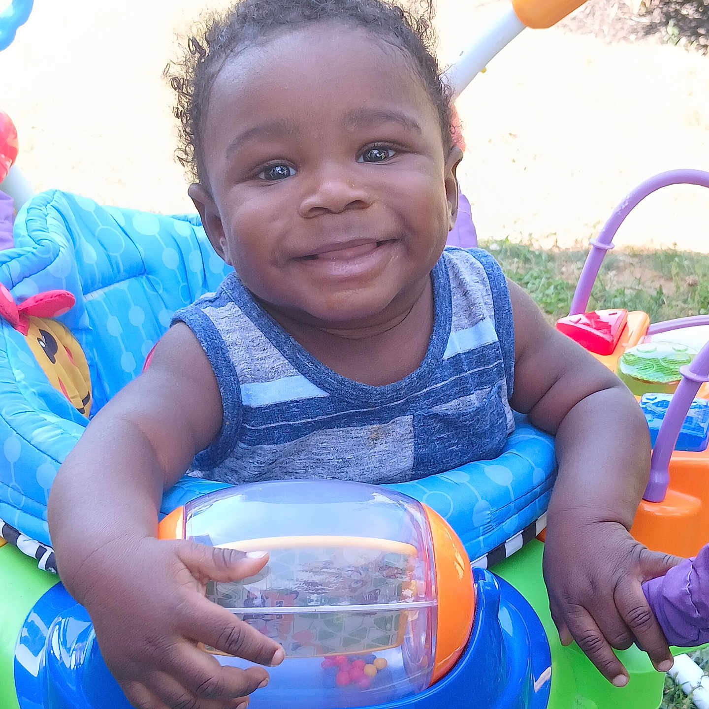 Benjamin is registered to the contest to win money with this photo: baby, clothing, face, glove, grass, happy, head, nature, outdoorplayarea, outdoors, park, person, photography, plant, playarea, portrait, smile, summer, toy, vest