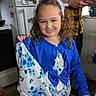 child, girl, smiling, bunny_ears, blue_clothing, curly_hair, indoor, kitchen, refrigerator, adult, hand, floor, door, window, patterned_clothing, person, holding, portrait, happy, casual