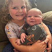 Davidson joined the competition — help win amazing prizes! child, baby, smiling, curly_hair, pajamas, couch, hugging, happy, indoor, window, natural_light, family, cute, infant, sitting, holding, portrait, cozy, comfort, young