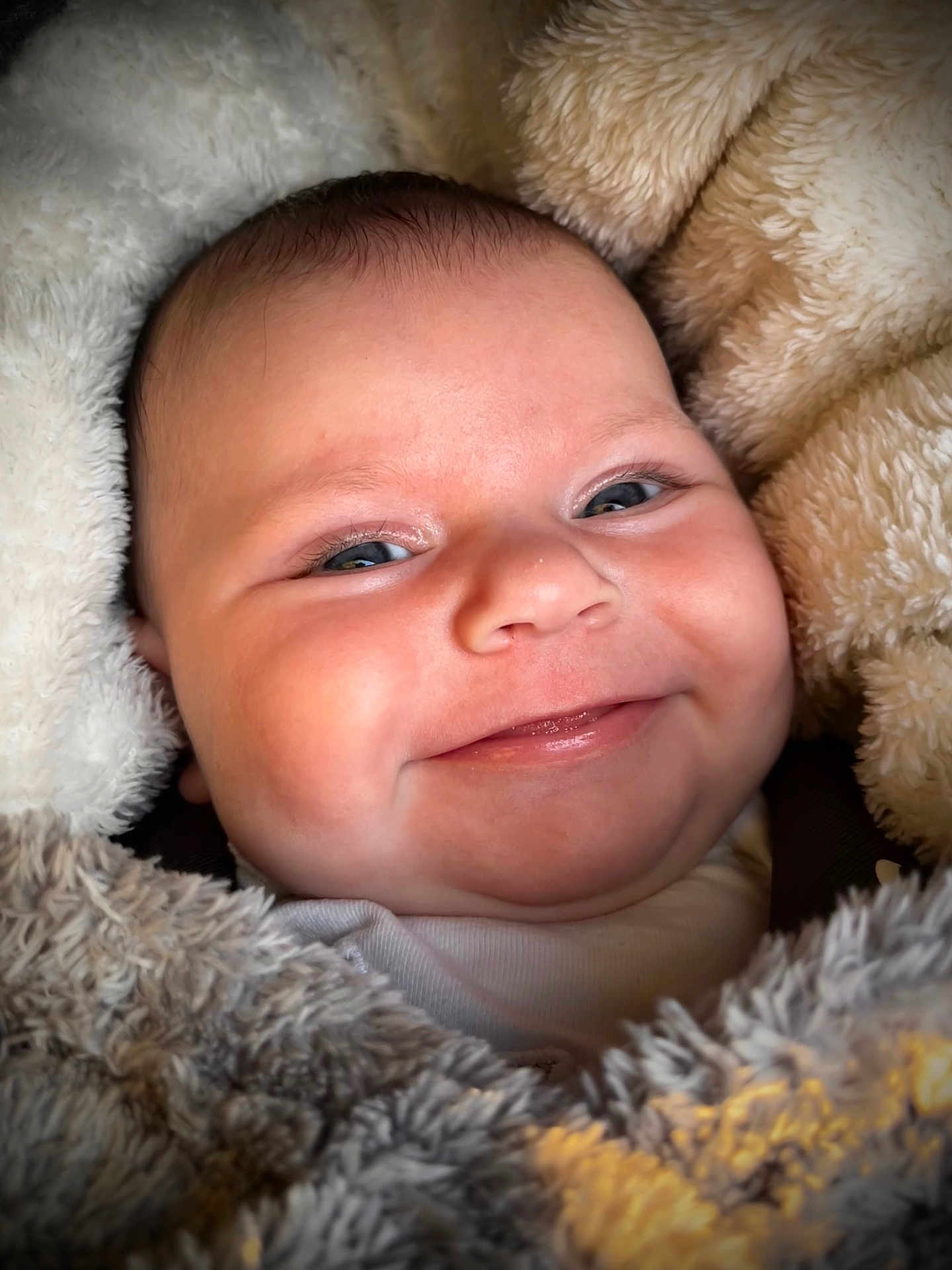 Victoire participe au concours pour gagner de l'argent avec cette photo : baby, smiling, face, blanket, cozy, infant, child, closeup, soft, cute, happy, warm, portrait, skin, young, head, expression, comfort, fuzzy, babyclothes