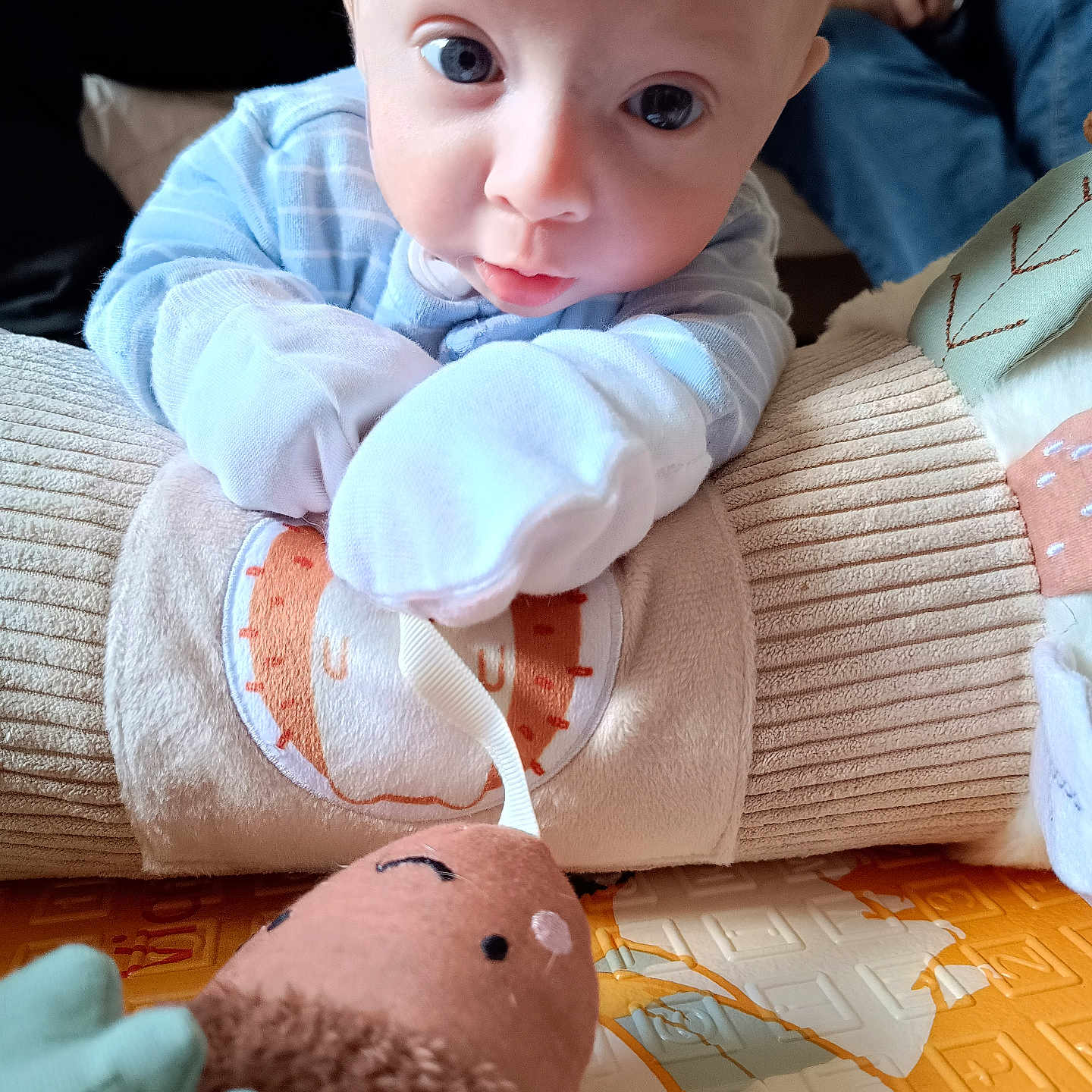 Alexander Owen is registered to the contest to win money with this photo: baby, blue_pajamas, child, close_up, comfort, cushion, cute, expression, fabric, floor_mat, hand, home, indoor, infant, person, play, resting, skin, soft_toy, toy