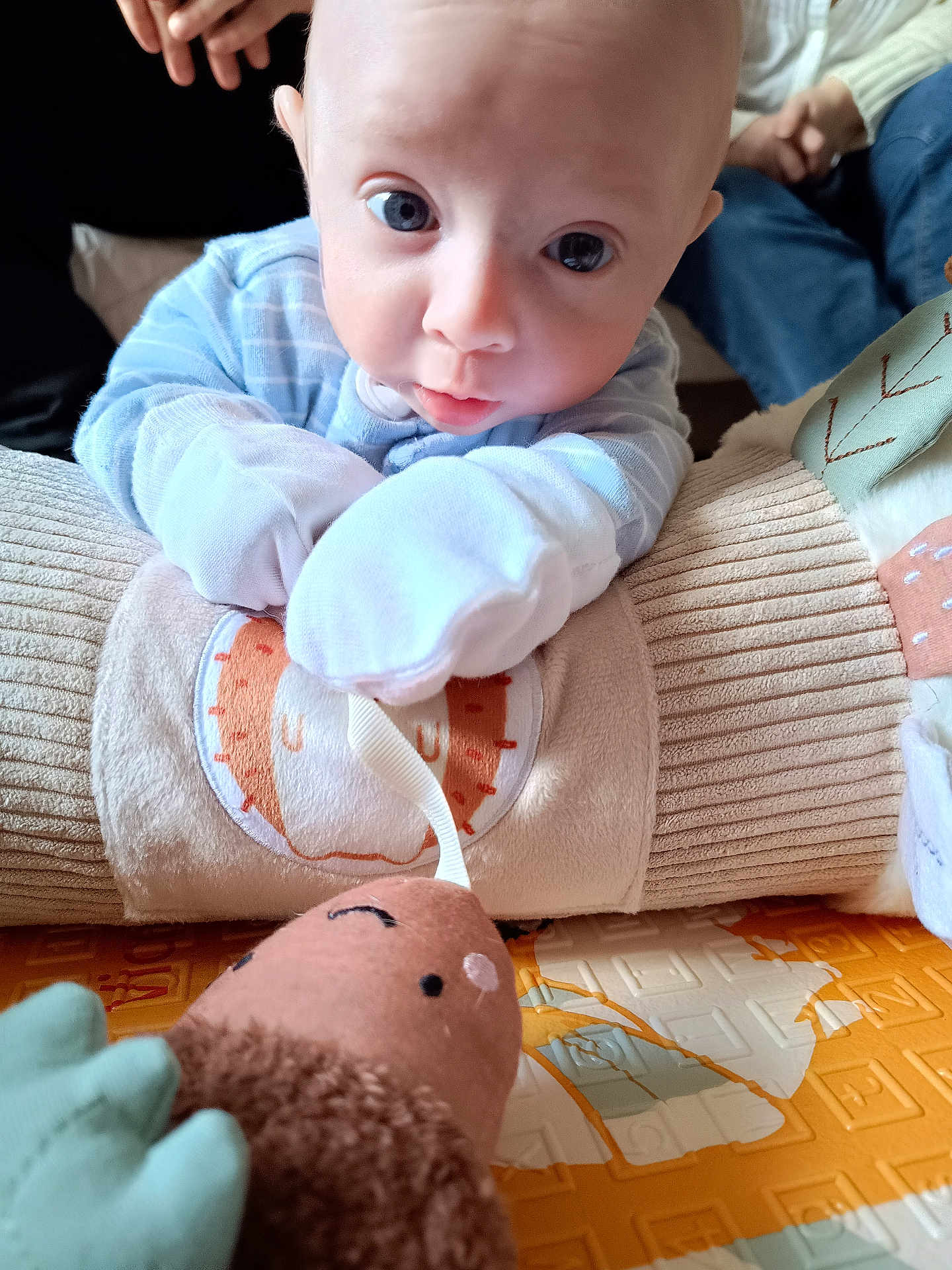 Alexander Owen is registered to the contest to win money with this photo: baby, infant, blue_pajamas, soft_toy, cushion, hand, floor_mat, indoor, close_up, person, child, cute, expression, resting, play, toy, fabric, comfort, home, skin