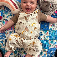 Joey joined the competition — help win amazing prizes! baby, smiling, tongue_out, patchwork_quilt, plush_toy, rainbow_pillow, animal_print, overalls, infant, child, happy, cute, face, lying_down, fabric, soft_toy, colorful, playtime, indoors, person