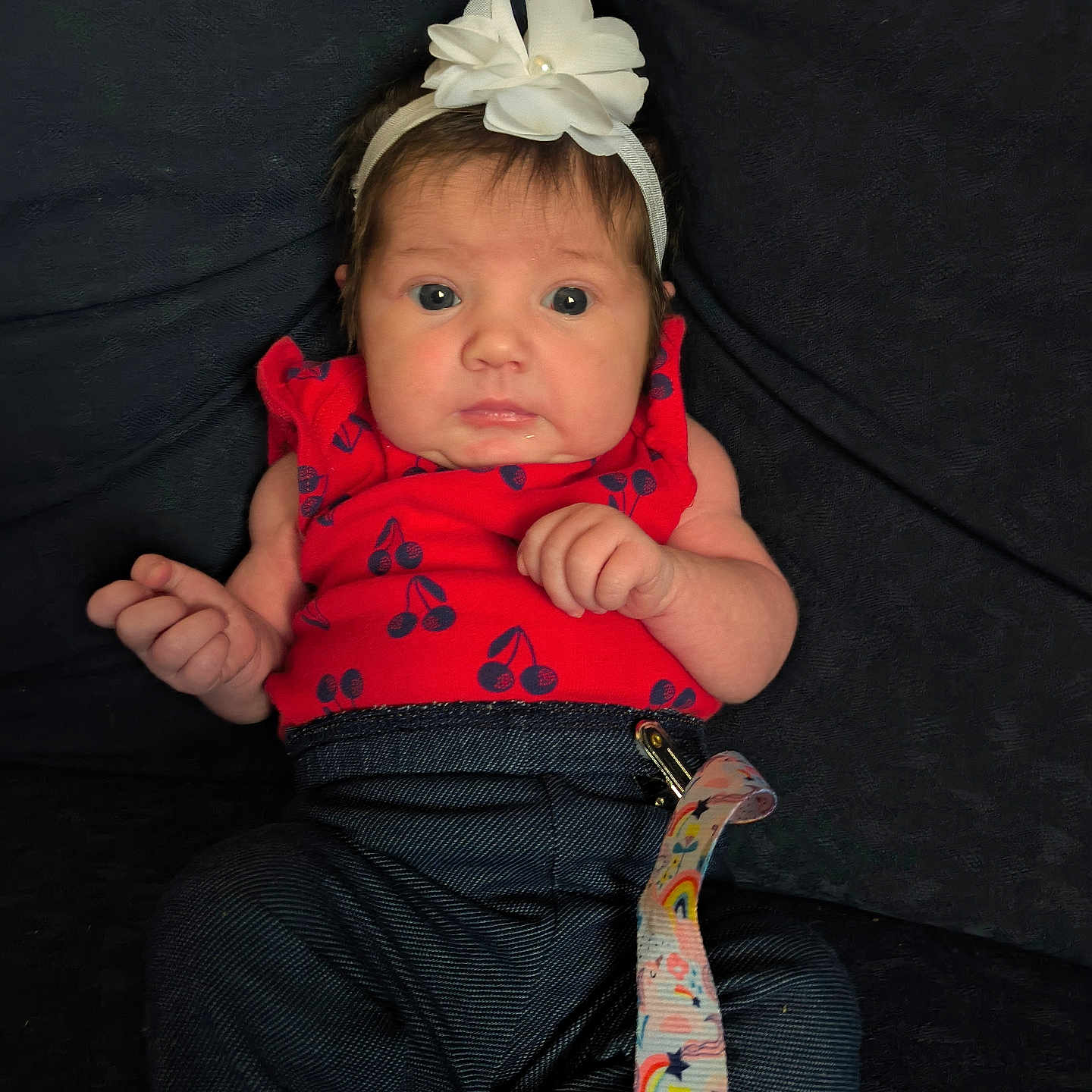 Madelyn is registered to the contest to win money with this photo: accessories, baby, bodypart, bonnet, clothing, couch, face, finger, formalwear, furniture, hand, hat, head, headband, newborn, pants, person, photography, portrait, strap