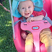 Maddox joined the competition — help win amazing prizes! baby, child, infant, smiling, happy, outdoor, swing, playground, sun_hat, pink_seat, safety_bar, grass, garden, portrait, face, hands, feet, colorful_clothing, summer, joy