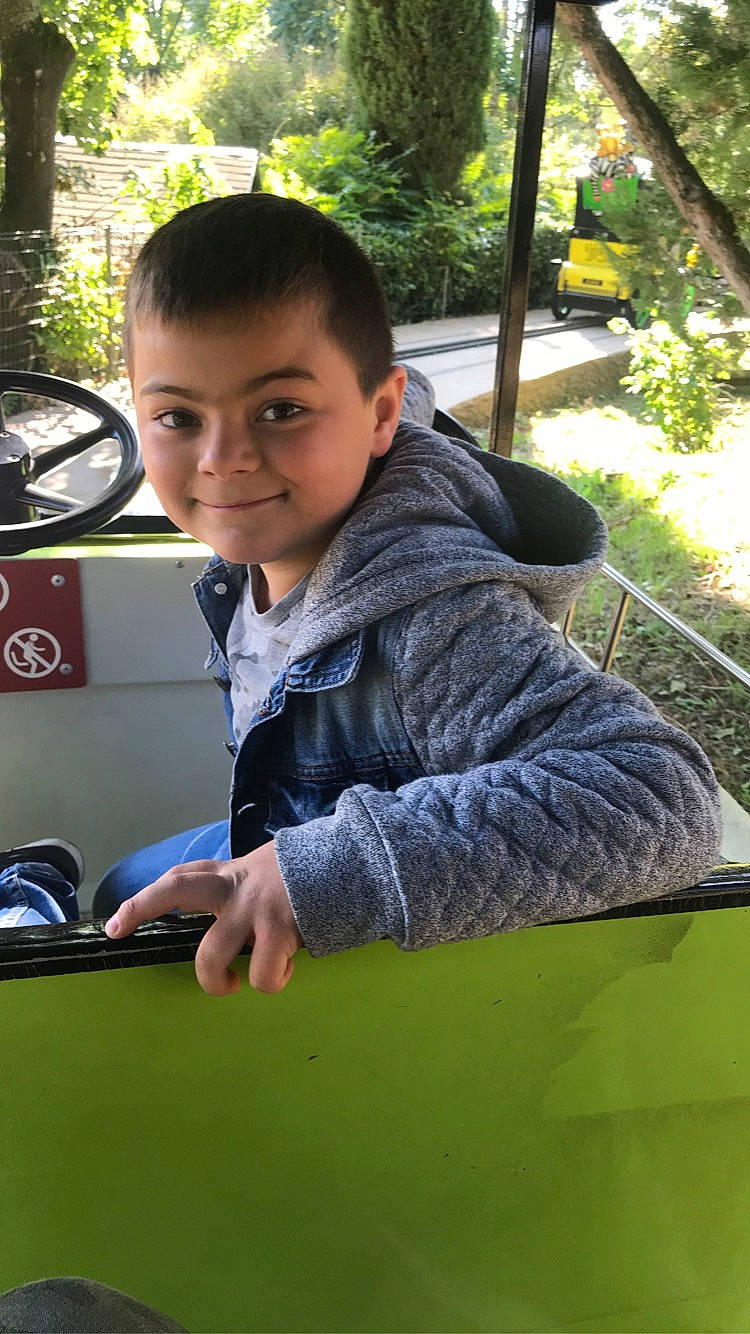 Elio a rejoint le concours — aidez-le/la à gagner de superbes lots ! auto_part, automotive_exterior, child, facial_expression, fun, grass, hairstyle, happy, joy, leisure, luxury_vehicle, motor_vehicle, person, plant, recreation, sitting, smile, travel, tree, vehicle_door