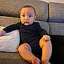 Aymen participe au concours pour gagner de l'argent avec cette photo : baby, child, infant, couch, sofa, cushion, indoors, person, clothing, onesie, feet, legs, face, head, skin, sitting, expression, curious, home, comfortable