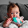 Maisie Jo is registered to the contest to win money with this photo: baby, infant, teething, mitten, blanket, blue_eyes, curly_hair, couch, indoor, cute, child, person, soft_texture, closeup, comfort, young, hand, expression, adorable, warm