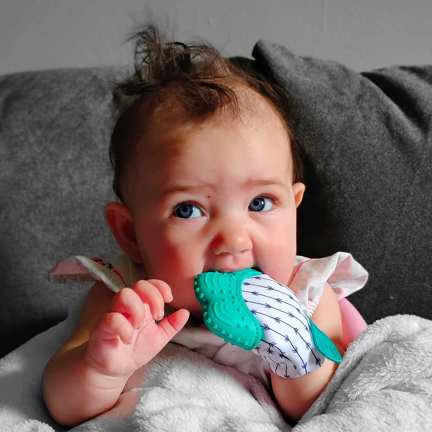 Maisie Jo is registered to the contest to win money with this photo: adorable, baby, blanket, blue_eyes, child, closeup, comfort, couch, curly_hair, cute, expression, hand, indoor, infant, mitten, person, soft_texture, teething, warm, young