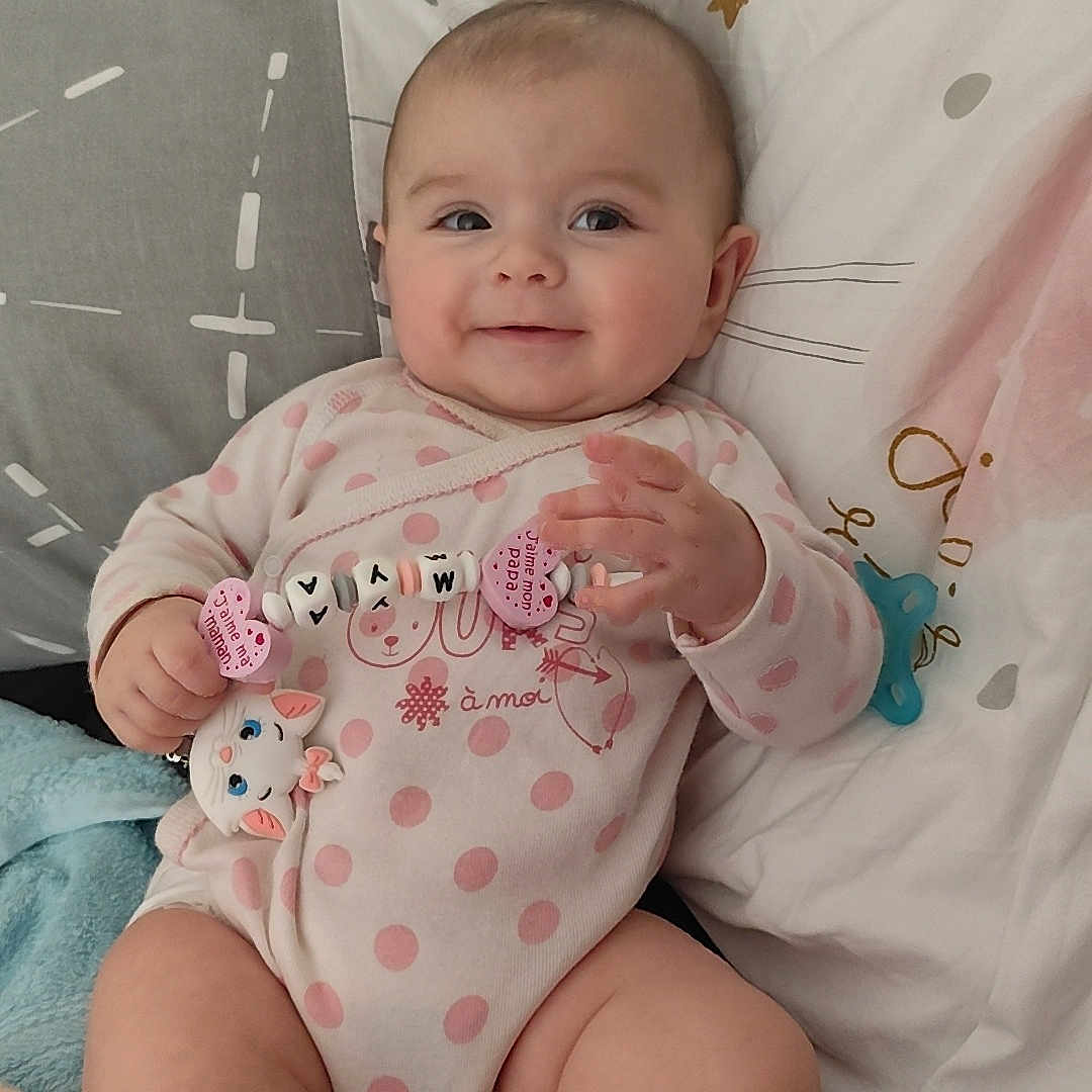 Mya participe au concours pour gagner de l'argent avec cette photo : baby, bed, blanket, cat_toy, child, chubby_legs, comfort, cute, face, hand, happy, indoor, infant, pillow, pink_onesie, polka_dots, resting, smiling, soft, toy