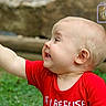 baby, child, smiling, red_shirt, outdoor, toy, grass, happy, portrait, cute, infant, playful, young_child, face, head, hand, greenery, nature, expression, photography