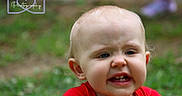 Roger is registered to the contest to win money with this photo: toddler, child, face, expression, grimace, red_shirt, outdoor, grass, portrait, blurry_background, head, cute, young_child, photography, watermark, logo, emotion, person, skin, hair