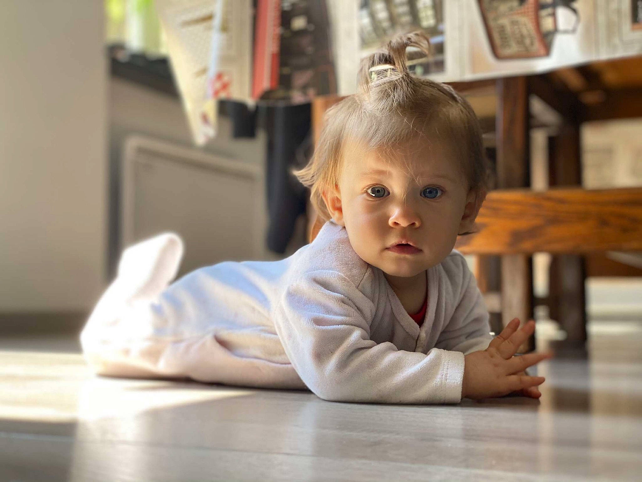 Hilona a rejoint le concours — aidez-le/la à gagner de superbes lots ! baby, blond, cheek, desk, floor, flooring, fun, happy, hardwood, head, leisure, person, picture_frame, room, shelf, sitting, table, toddler, varnish, wood
