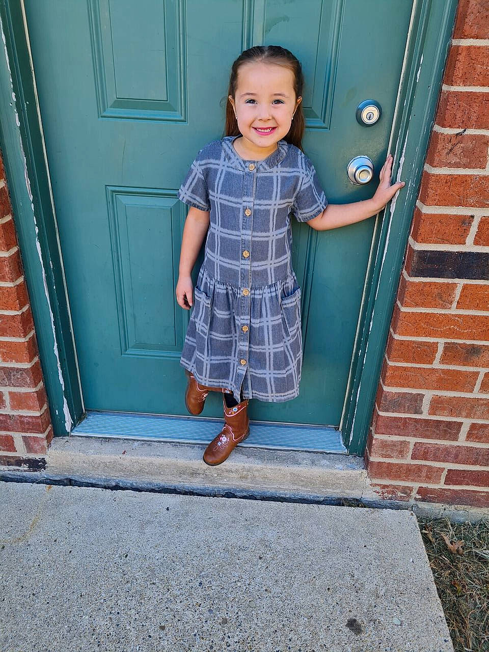 Gabrielle is registered to the contest to win money with this photo: baby_toddler_clothing, brick, brickwork, child, day_dress, door, dress, electric_blue, face, human_leg, joy, one_piece_garment, pattern, person, road_surface, sleeve, smile, stairs, tints_and_shades, toddler
