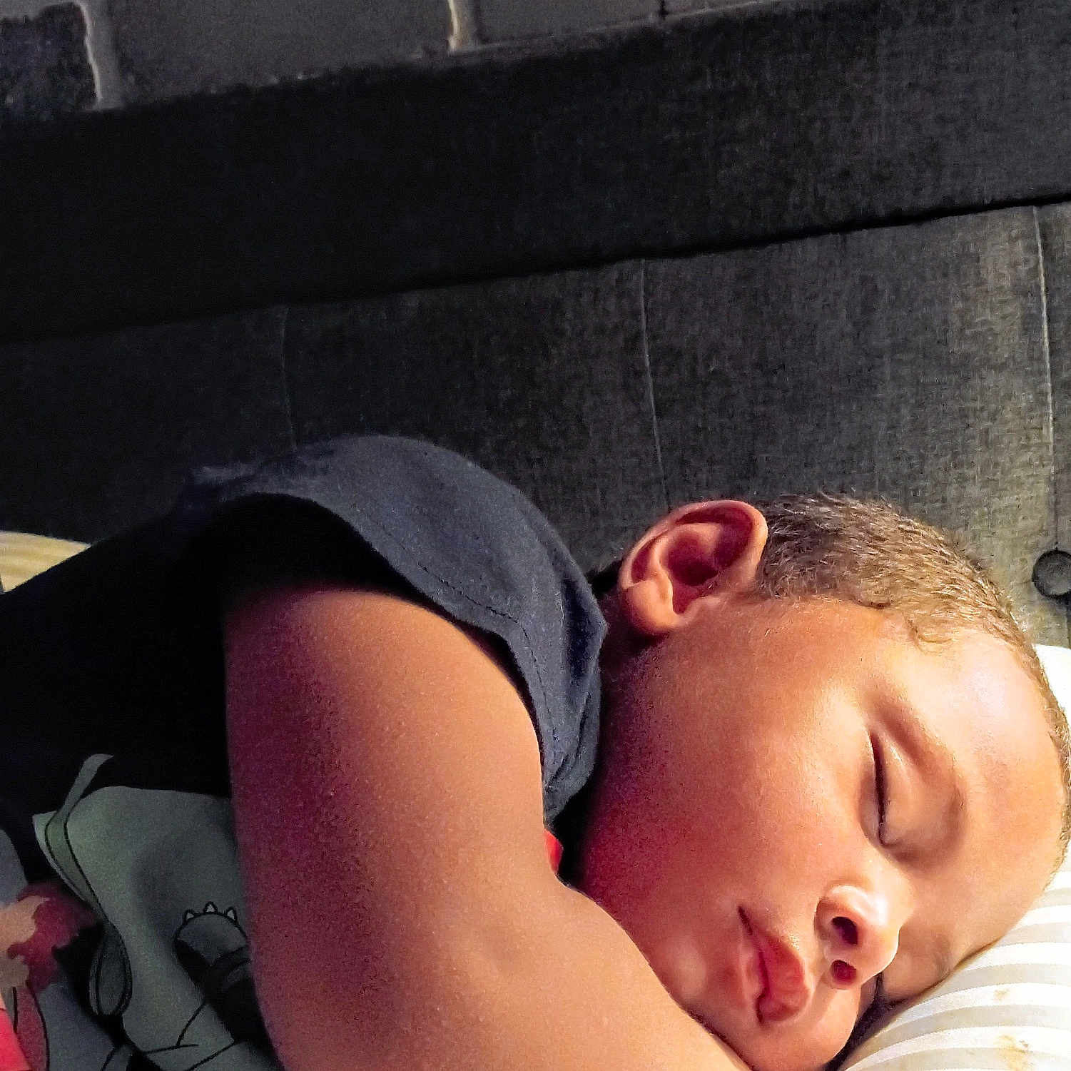 Ronald is registered to the contest to win money with this photo: child, sleeping, toddler, pillow, bed, arm, face, cozy, indoor, rest, peaceful, curly_hair, striped, fabric, cute, young, portrait, relaxation, comfort, nap