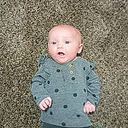 Faith is registered to the contest to win money with this photo: baby, barefoot, carpet, child, clothing, cute, expression, face, floor, head, indoor, infant, lying_down, pants, person, polka_dot, portrait, shirt, skin, young