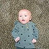 baby, barefoot, carpet, child, clothing, cute, expression, face, floor, head, indoor, infant, lying_down, pants, person, polka_dot, portrait, shirt, skin, young