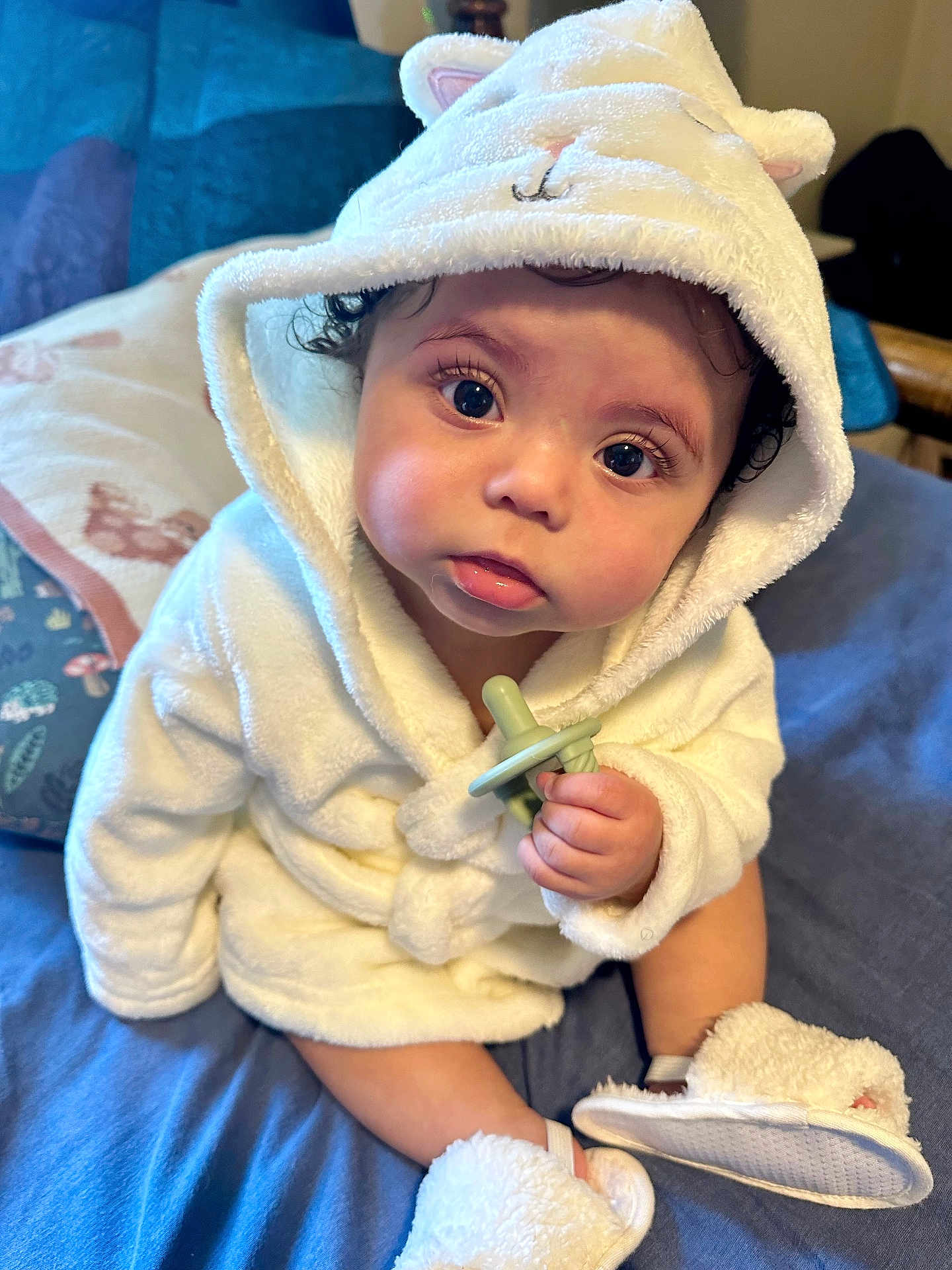 Nomi is registered to the contest to win money with this photo: baby, bodypart, bonnet, clothing, couch, face, finger, footwear, hand, hat, head, hood, hoodie, knitwear, person, photography, portrait, shoe, sweater, sweatshirt