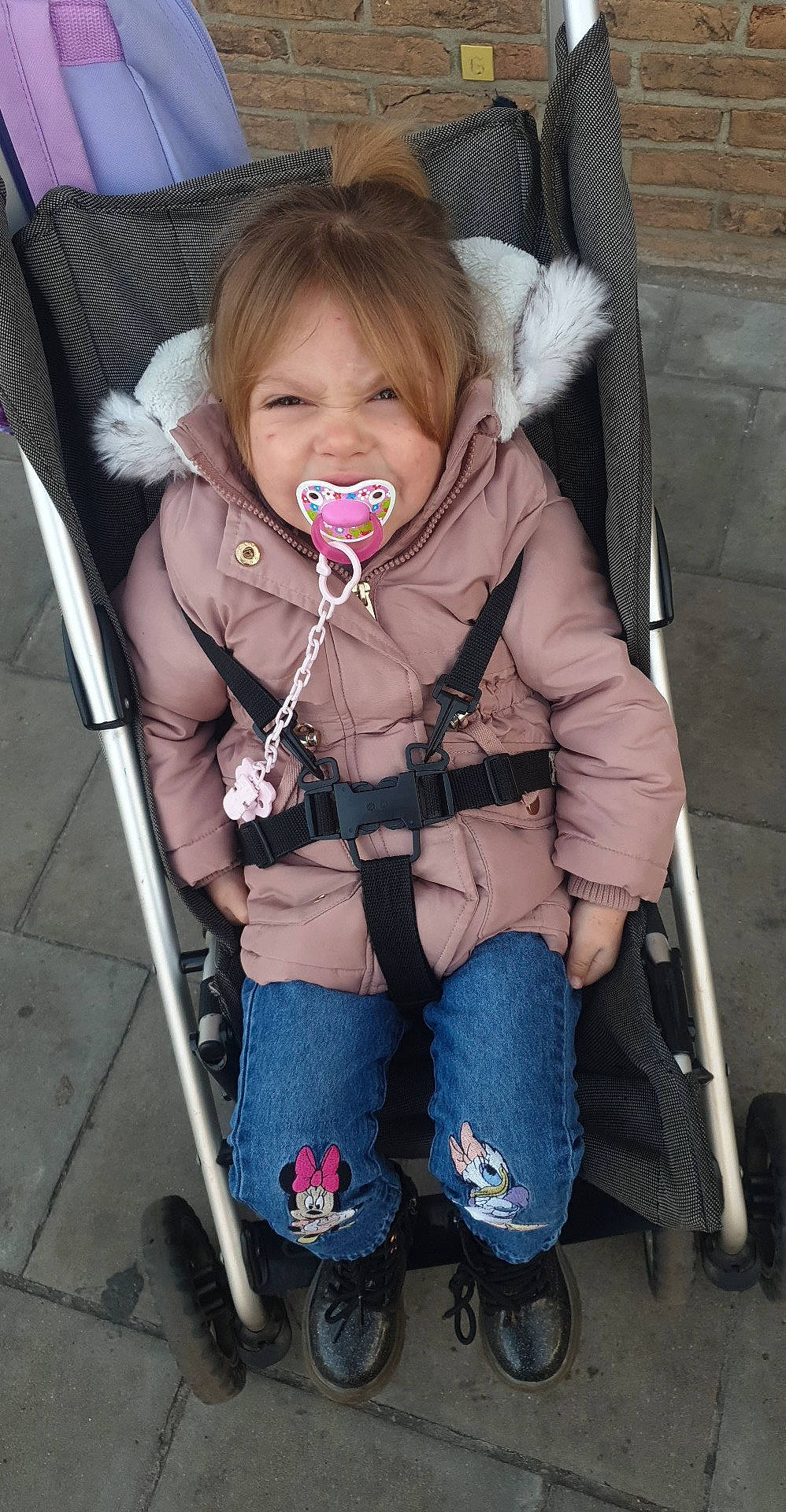 Inaya participe au concours pour gagner de l'argent avec cette photo : baby, baby_carriage, baby_products, baby_toddler_clothing, cheek, child, clothing, electric_blue, eye, face, fashion_accessory, fun, head, iris, jacket, person, personal_protective_equipment, sitting, skin, sleeve