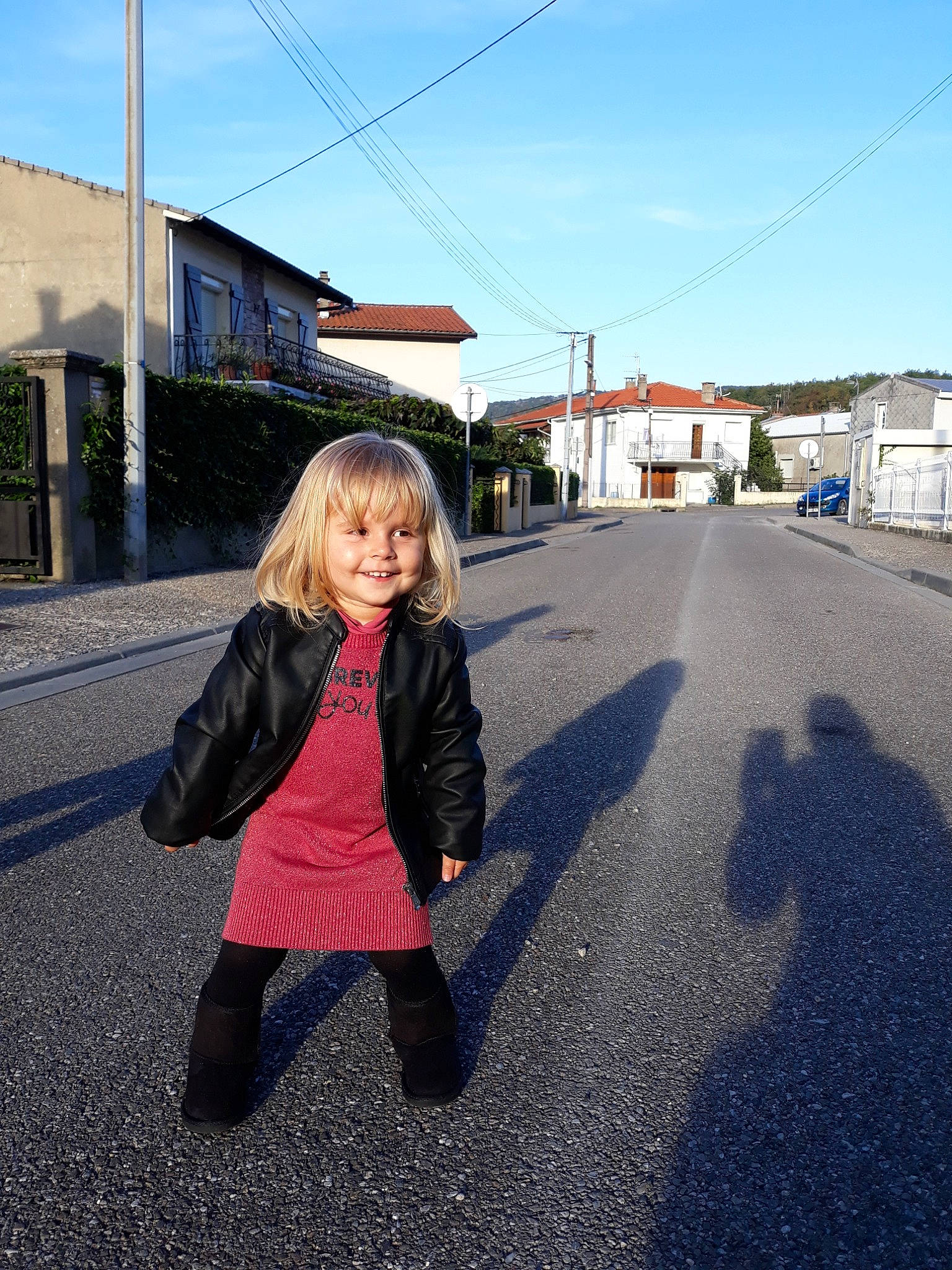 Sofia participe au concours pour gagner de l'argent avec cette photo : asphalt, blue, car, child, fun, girl, house, infrastructure, joy, pedestrian, person, photograph, public_space, recreation, road, sky, smile, snapshot, street, travel