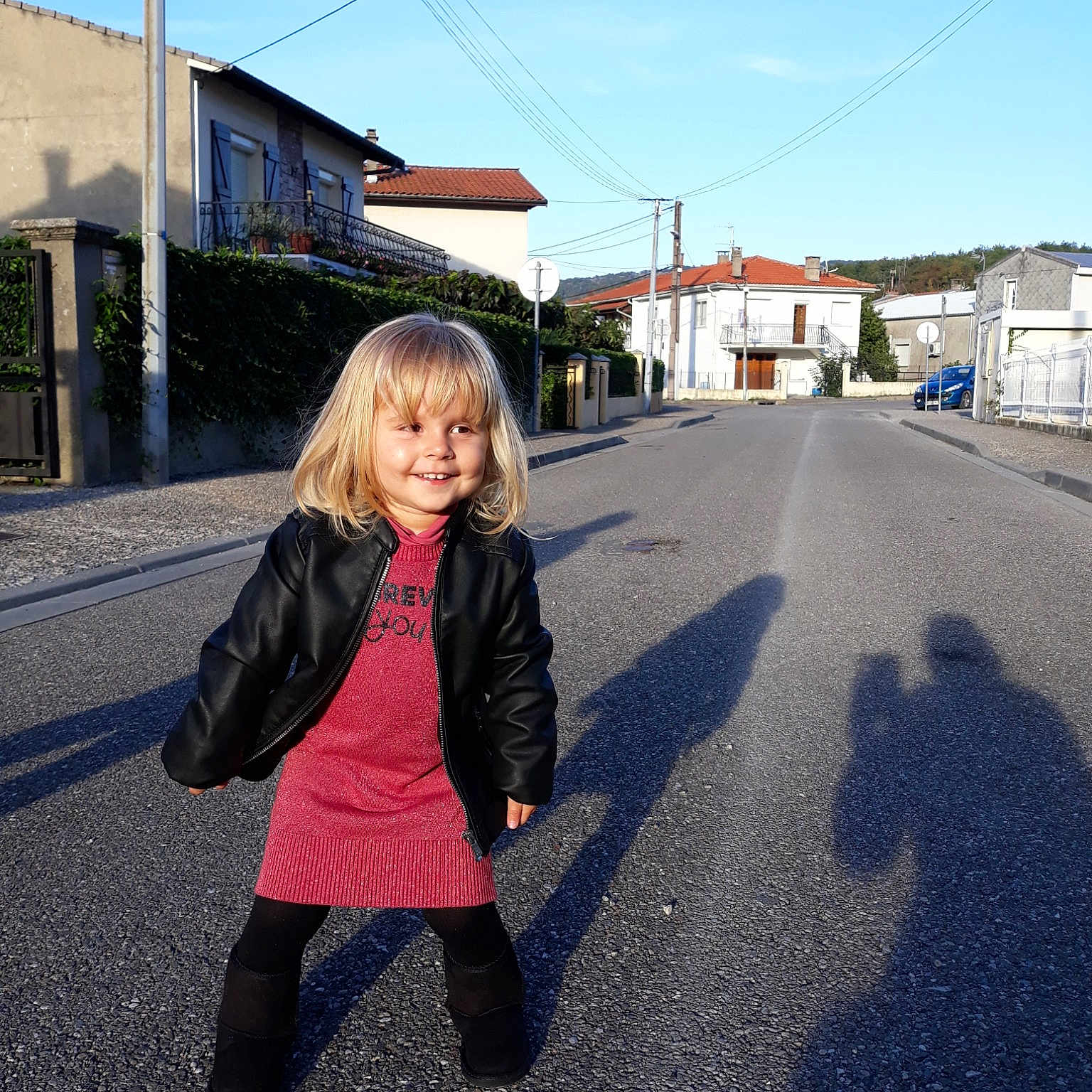 Sofia participe au concours pour gagner de l'argent avec cette photo : asphalt, blue, car, child, fun, girl, house, infrastructure, joy, pedestrian, person, photograph, public_space, recreation, road, sky, smile, snapshot, street, travel