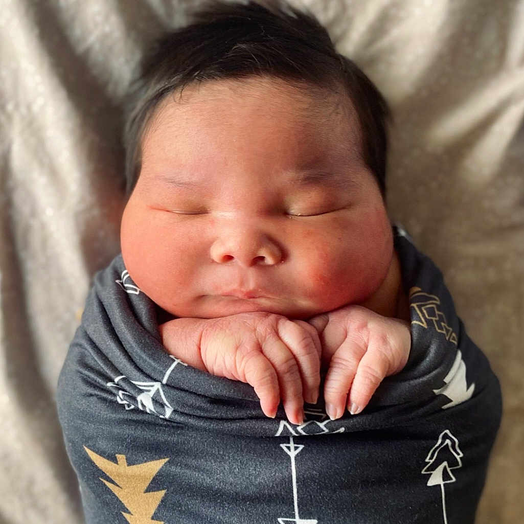 Colton is registered to the contest to win money with this photo: baby, blanket, clothing, coat, face, head, newborn, person, photography, portrait, skin, sleeping, yawning