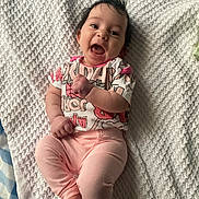 Rosalie is registered to the contest to win money with this photo: baby, infant, smile, laughing, face, eyes, hair, blanket, textured_blanket, onesie, pink_pants, laying_down, bed, cotton, cute, happy, mouth_open, hand, feet, portrait