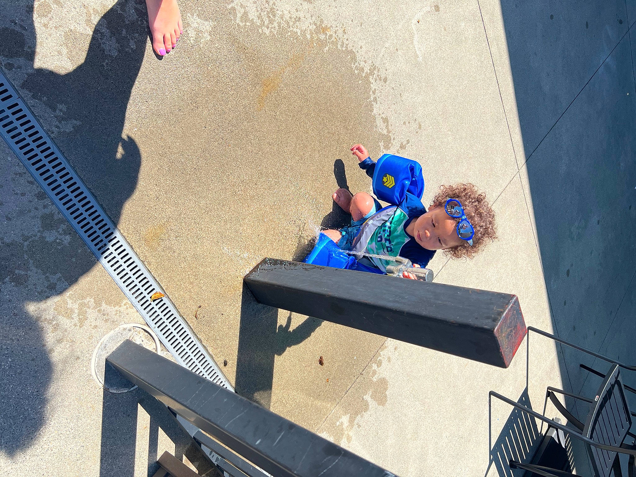 Royce is registered to the contest to win money with this photo: asphalt, concrete, electric_blue, fun, guitar, headwear, landscape, leisure, musical_instrument, person, recreation, road_surface, shadow, sidewalk, sitting, soil, street, water