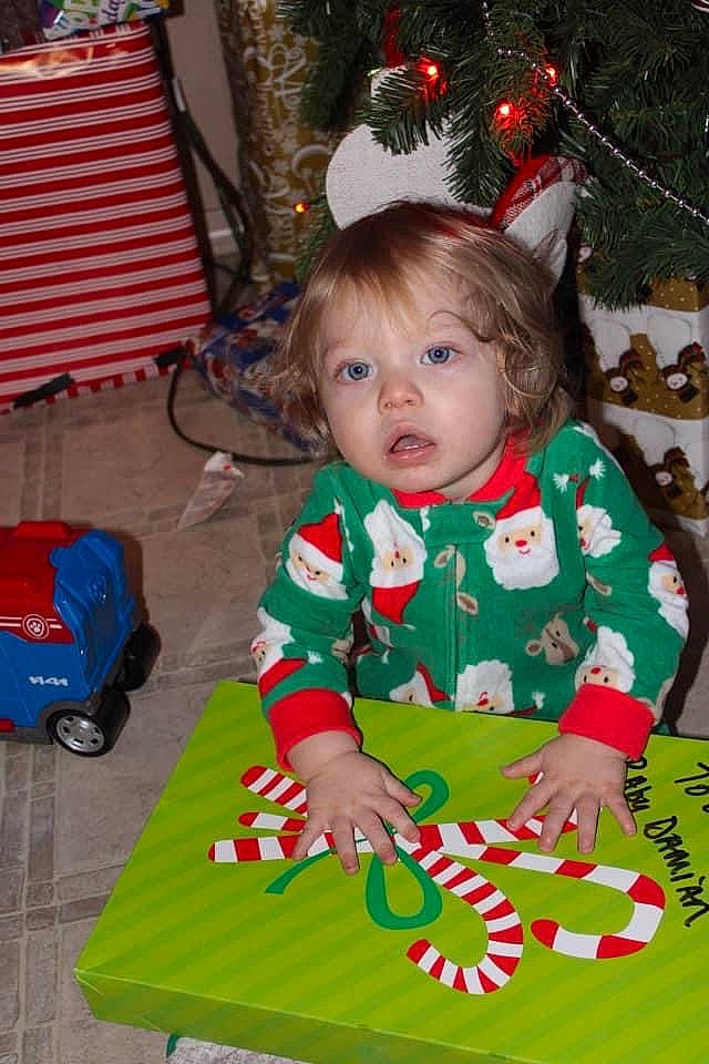 Damian joined the competition — help win amazing prizes! baby, baby_toddler_clothing, child, christmas, christmas_decoration, christmas_eve, christmas_ornament, christmas_tree, event, fun, grass, green, head, holiday, holiday_ornament, person, red, sitting, surprise, toddler