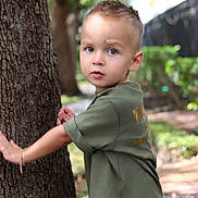 Kobi joined the competition — help win amazing prizes! child, toddler, boy, portrait, outdoors, tree, nature, garden, greenery, forest, standing, looking_at_camera, curious, short_hair, t_shirt, camouflage_shorts, sunlight, bokeh, tree_trunk, path